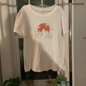 White t-shirt with mountain landscape.